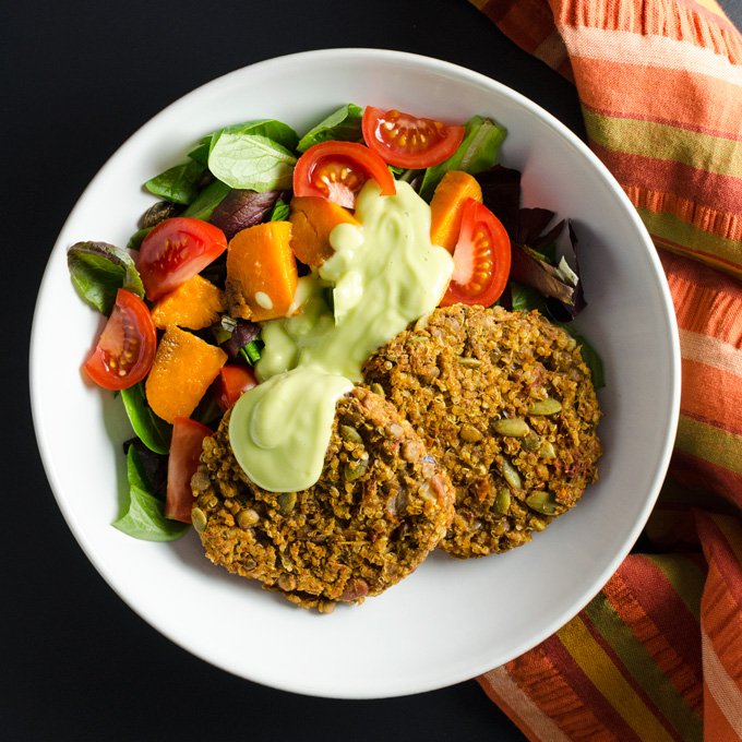 Spicy Lentil Quinoa Burgers with avocado dressing overhead view