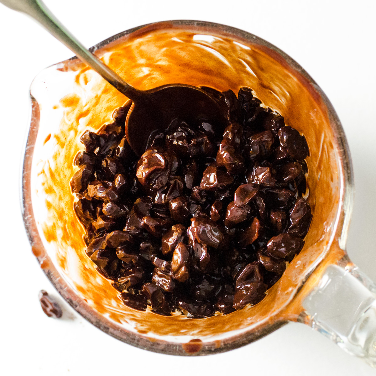 Raisins mixed with melted ingredients for homemade chocolate covered raisins