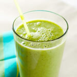 rosemary mango green smoothing in a glass with a yellow straw