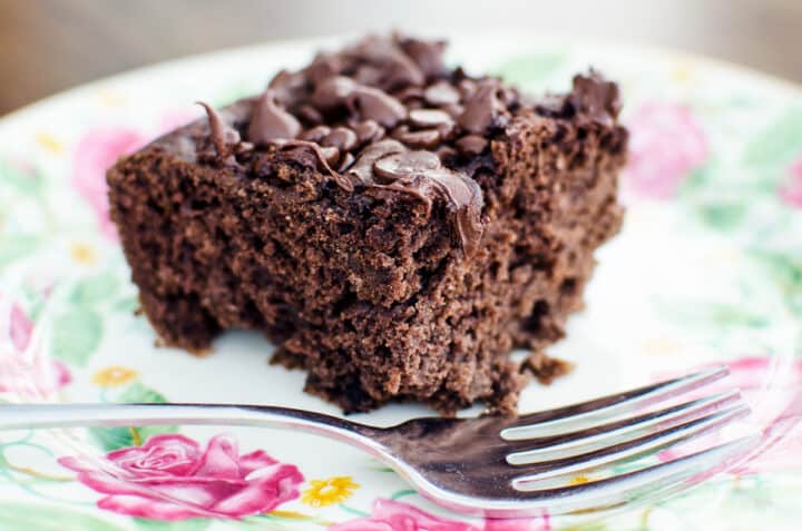 slice of vegan, gluten-free chocolate snack cake on a plate with a fork