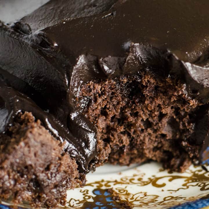 closeup of a slice of vegan, gluten-free snack cake with dark chocolate avocado frosting on top