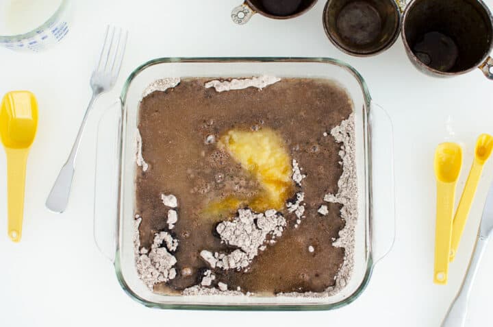 unmixed vegan, gluten-free chocolate snack cake ingredients in a glass baking dish