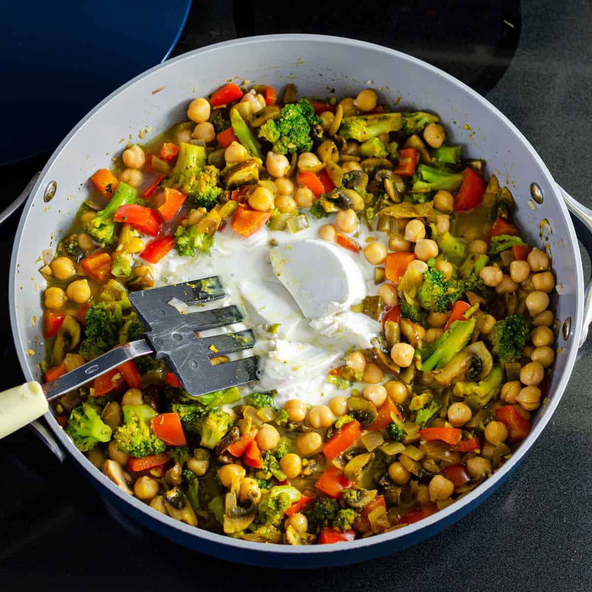 coconut milk added to sauté pan full of vegetables